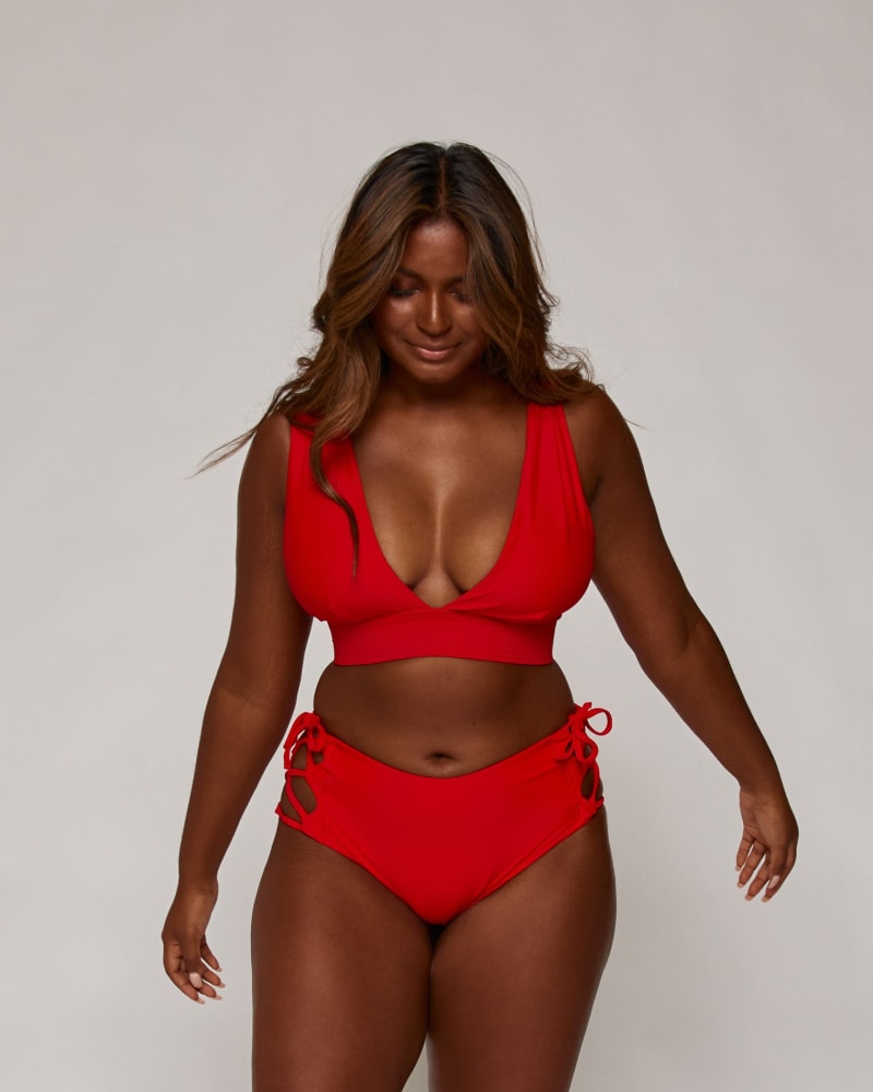 Front of a model wearing a size 10|12 Lola Side-Tie Bottoms in Lava by Wild Isles Swim. | dia_product_style_image_id:284905